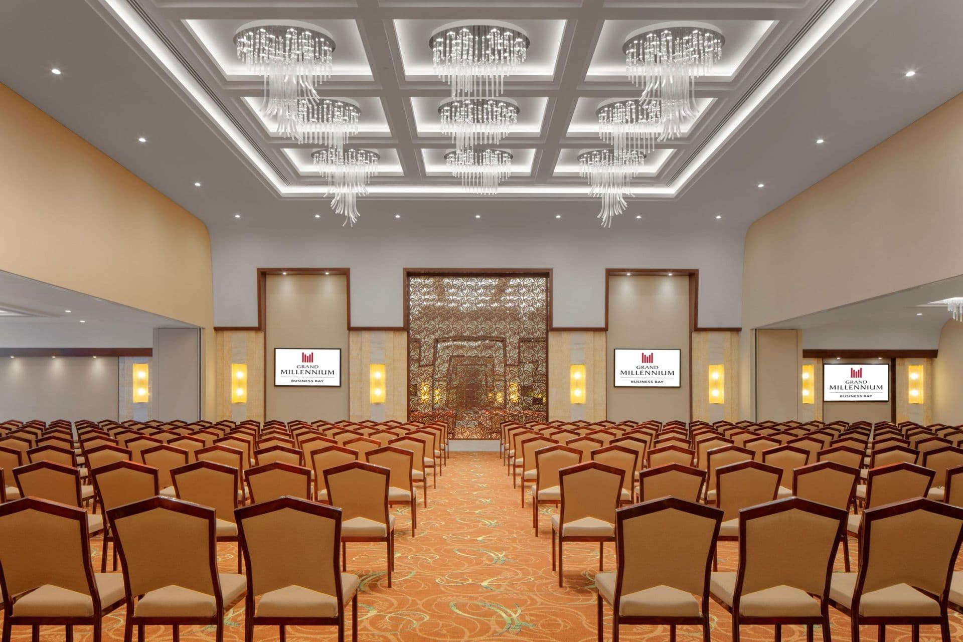 A hotel ballroom set out with rows of chairs facing a stage