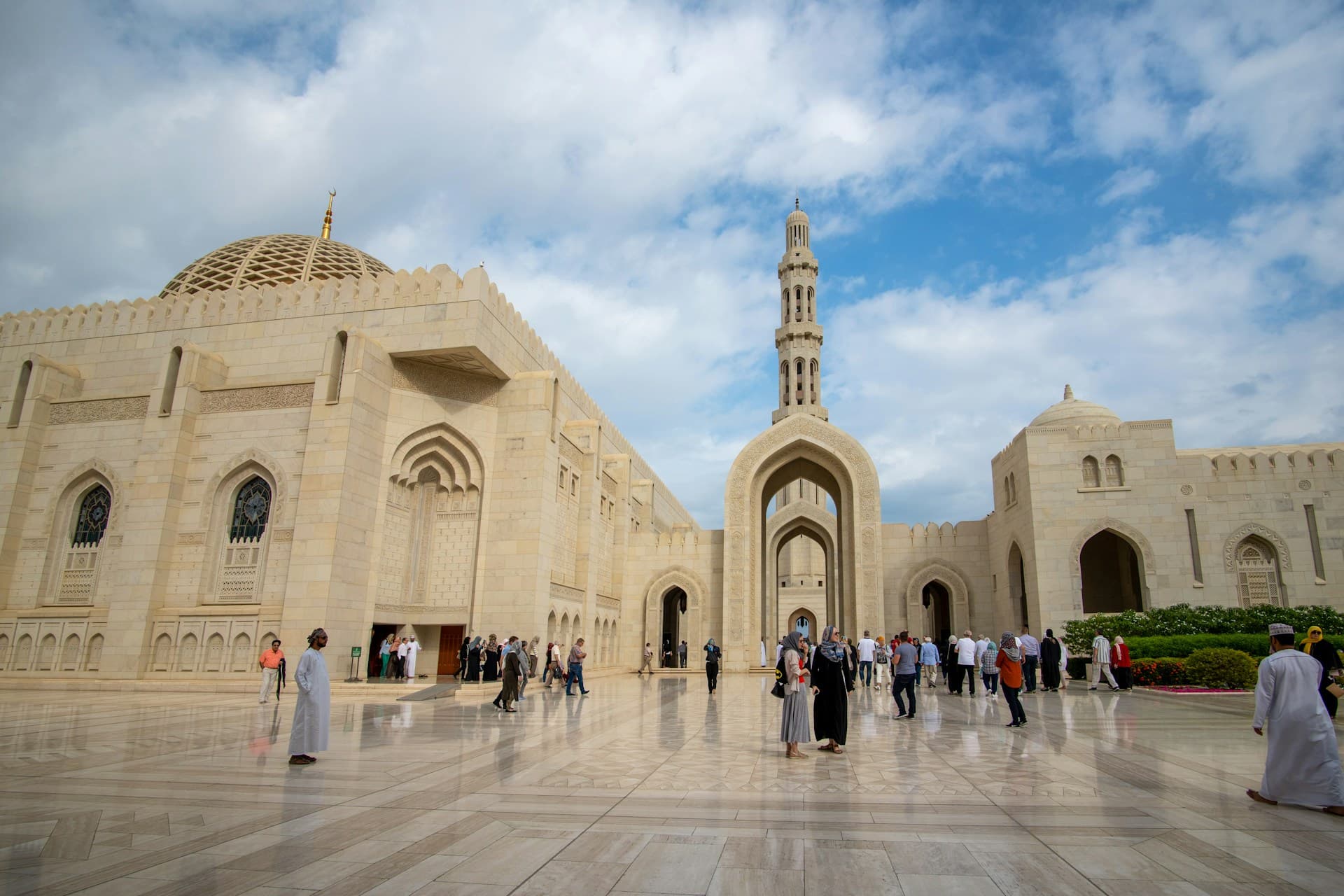 The Sultan Qaboos Grand Mosque in Muscat, Oman, under a blue sky