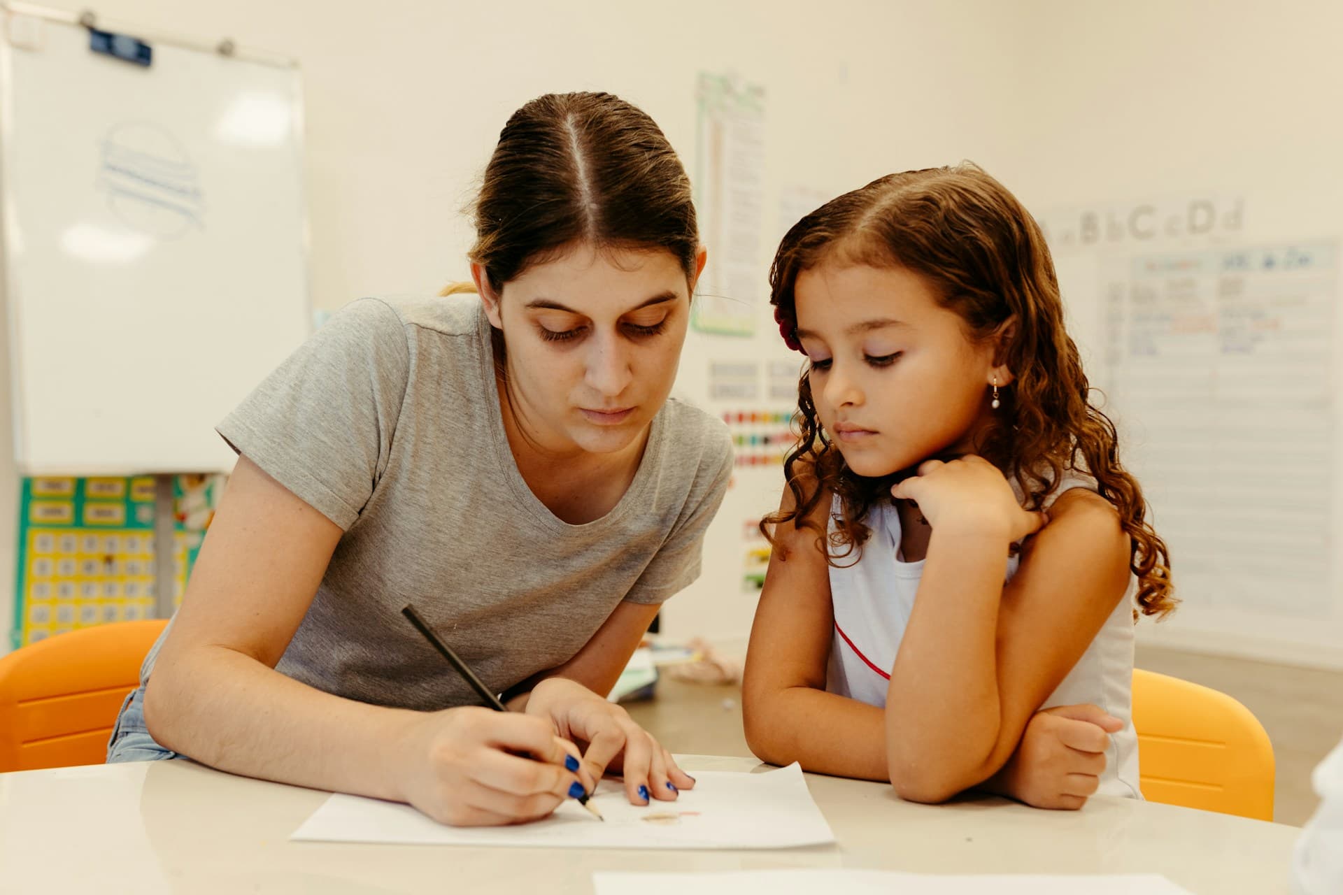 A teacher working one-to-one with a young pupil