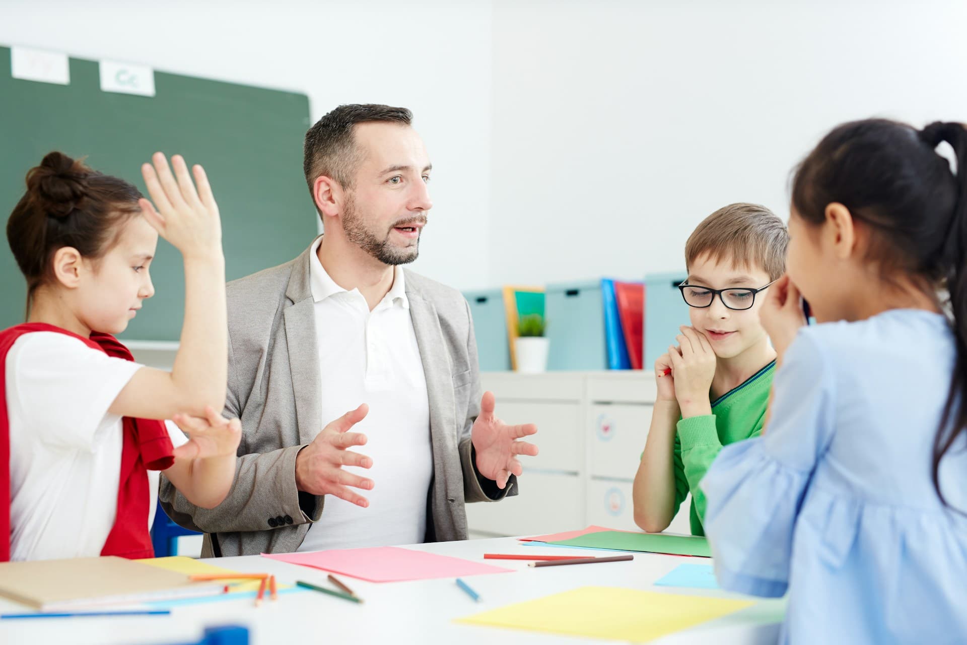 A teacher leading a lively discussion with a small group of primary pupils